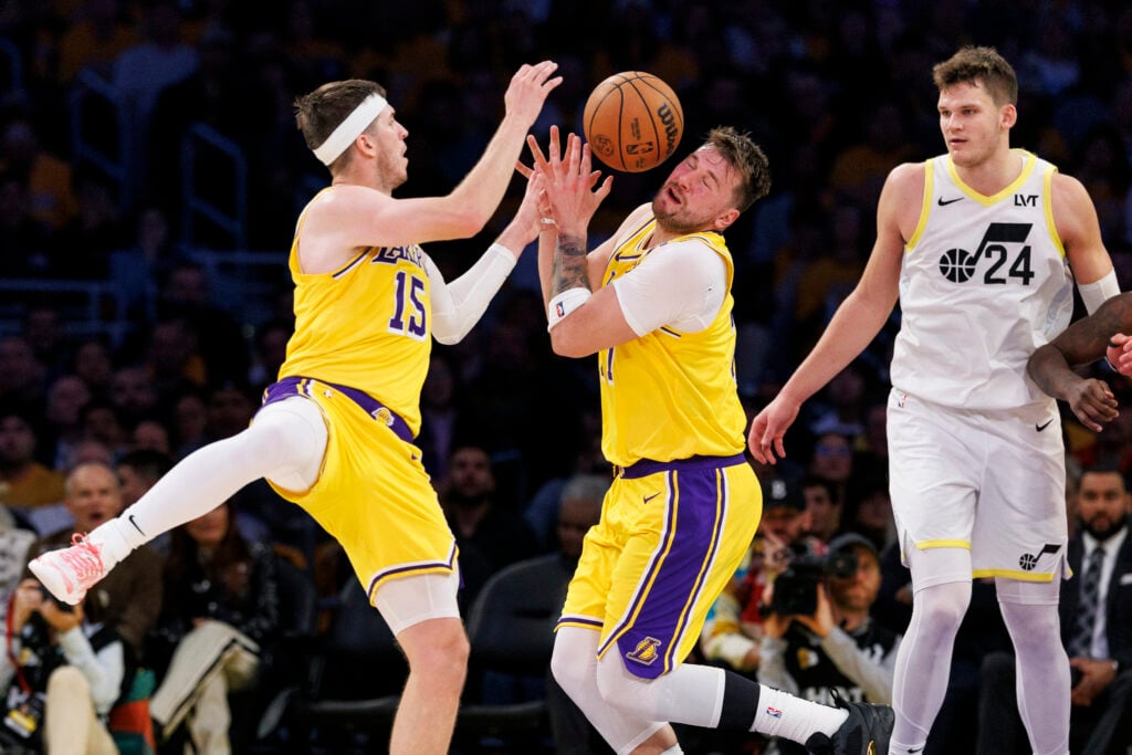 Los Angeles Lakers guard Austin Reaves (15) and Los Angeles Lakers guard Luka Doncic (77) team up to grab a loose ball in front of Utah Jazz center Walker Kessler (24) at Crypto.com Arena on February 10, 2025 in Los Angeles, California.