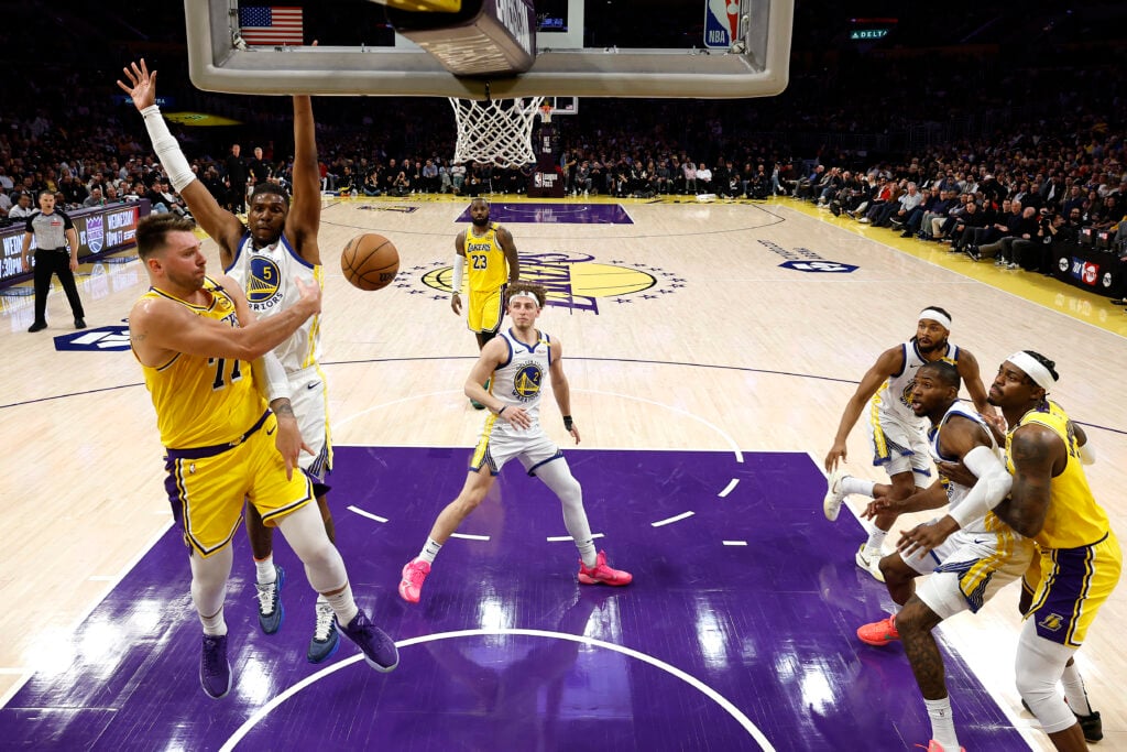 Luka Doncic #77 of the Los Angeles Lakers passes against Kevon Looney #5 of the Golden State Warriors during the second half of a game at Crypto.com Arena on April 03, 2025 in Los Angeles, California.