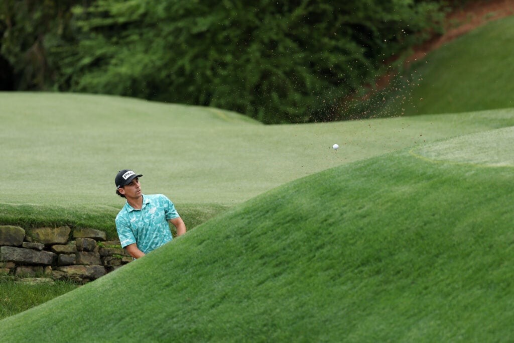 Joaquin Niemann chips from Rae's Creek during the first round of The Masters