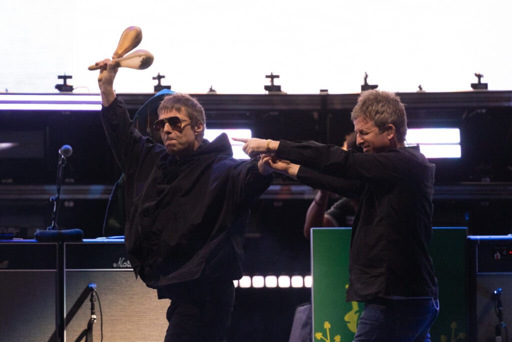 Liam and Noel Gallagher of British band Oasis walk together on stage to perform as part of their Live '25 global tour in Sydney Australia.