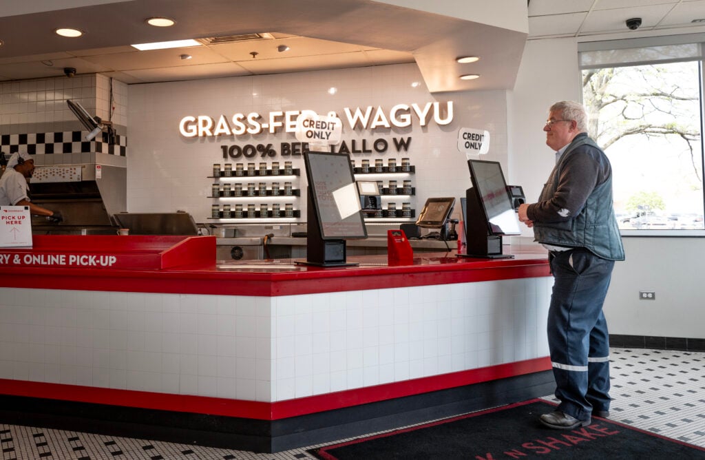 A customer orders food at a Steak 'n Shake restaurant.