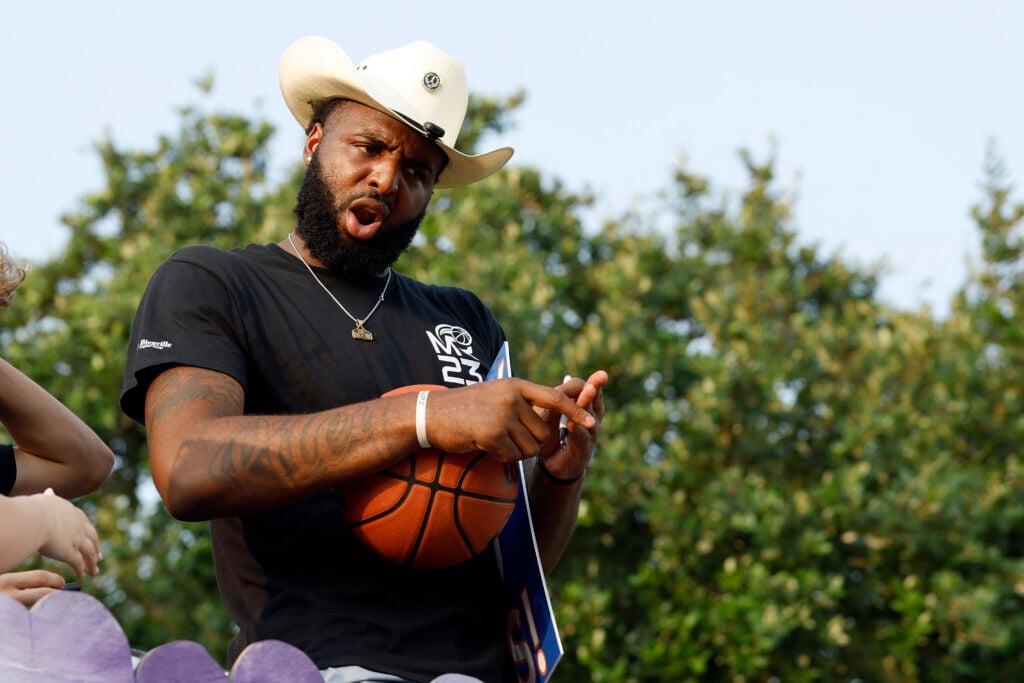 Mitchell Robinson rides in a hometown community parade as a member of the NBA champion New York Knicks.