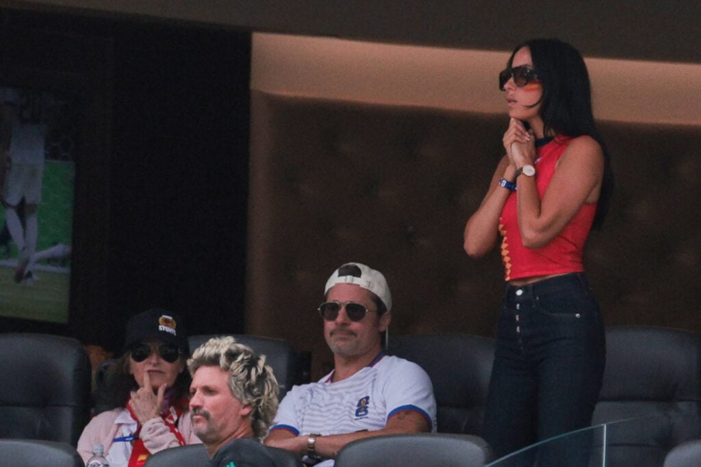 US actor Brad Pitt (C) and his partner Ines de Ramon (R) attend the 2026 World Cup football tournament quarter-final match between Spain and Belgium