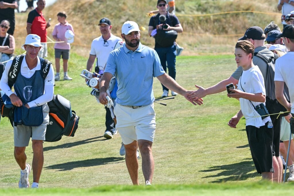 Scottie Scheffler of the US (C) is cheers on by fans on the 9th tee, as players practise a few days before the start of the 2026 Open Golf Championship at Royal Birkdale golf course near Southport in north-west England