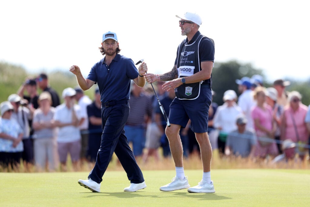 Tommy Fleetwood of England interacts with his caddie, Ian Finnis on the ninth green on day one of the Genesis Scottish Open 2026
