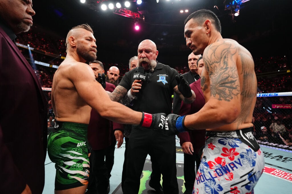 Conor McGregor of Ireland touches gloves with Max Holloway in a welterweight fight during the UFC 329 event.