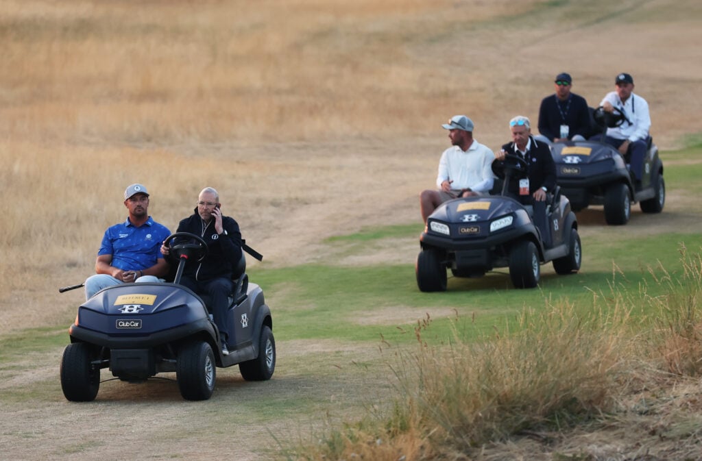 Bryson DeChambeau of the United States is driven by a rules offical on a buggy following day two of the The 154th Open Championship at Royal Birkdale